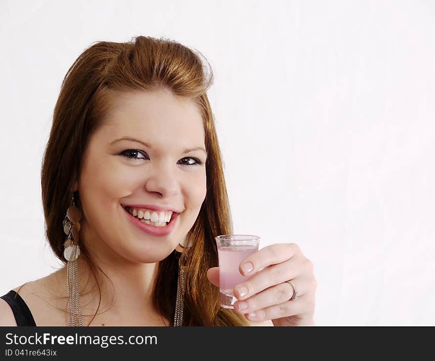 Smiling party brunette with long earrings raises a glass in welcome. On white with copy space. Smiling party brunette with long earrings raises a glass in welcome. On white with copy space.