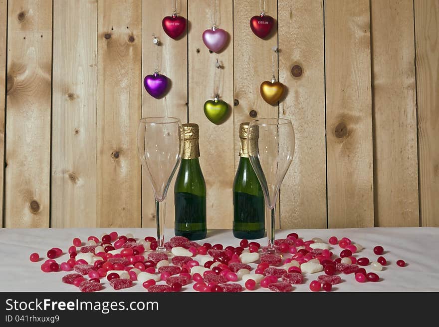 Candy harts,jelly beans and champagne on white and wood background. Candy harts,jelly beans and champagne on white and wood background