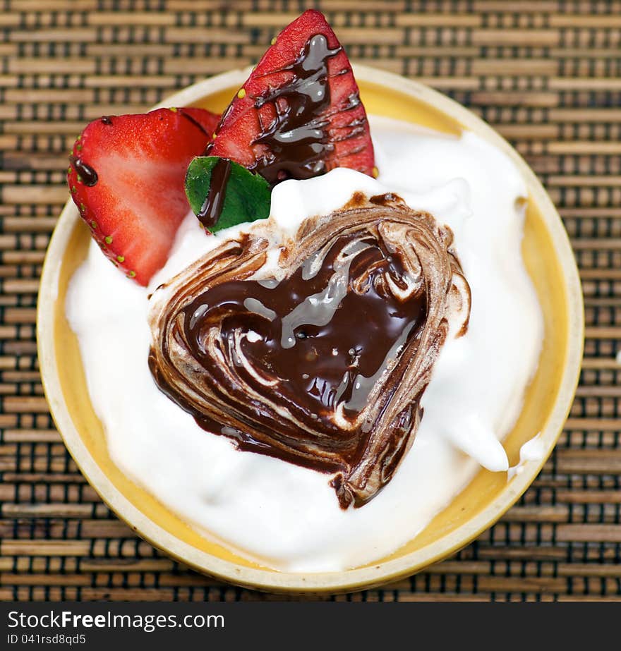 Delicious dessert with whipped creme and strawberry decorated chocolate heart. Delicious dessert with whipped creme and strawberry decorated chocolate heart