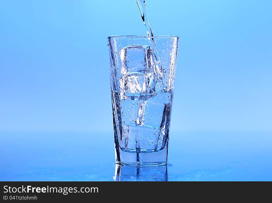 Crystal clear water with ice over blue background