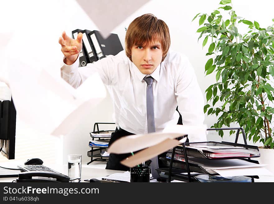 Angry businessman with documents in his office. Angry businessman with documents in his office