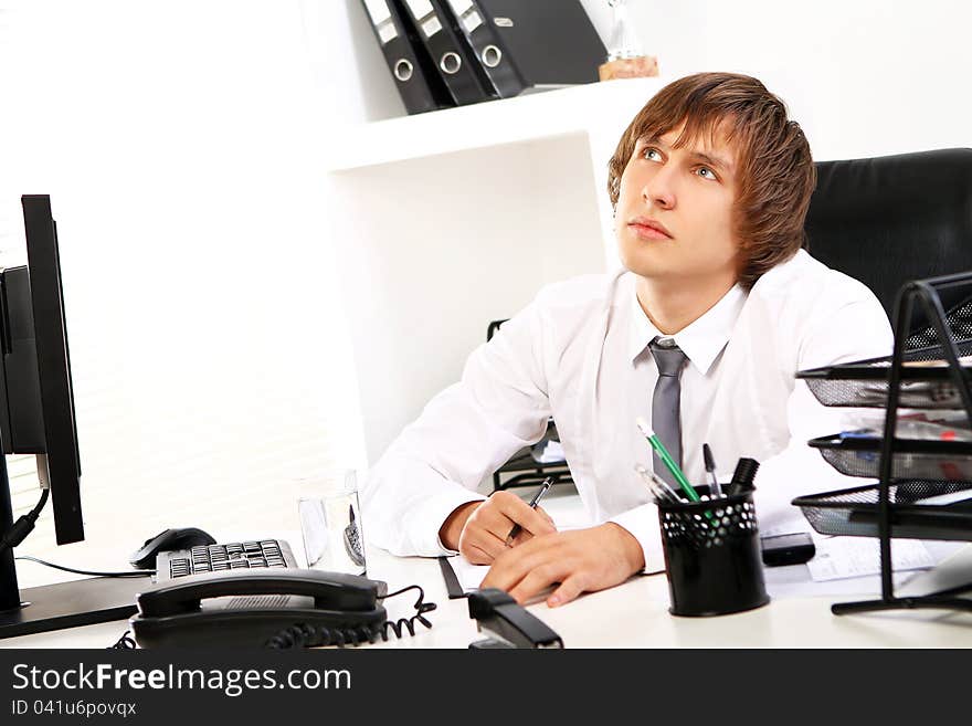 Young businessman thinking in his office