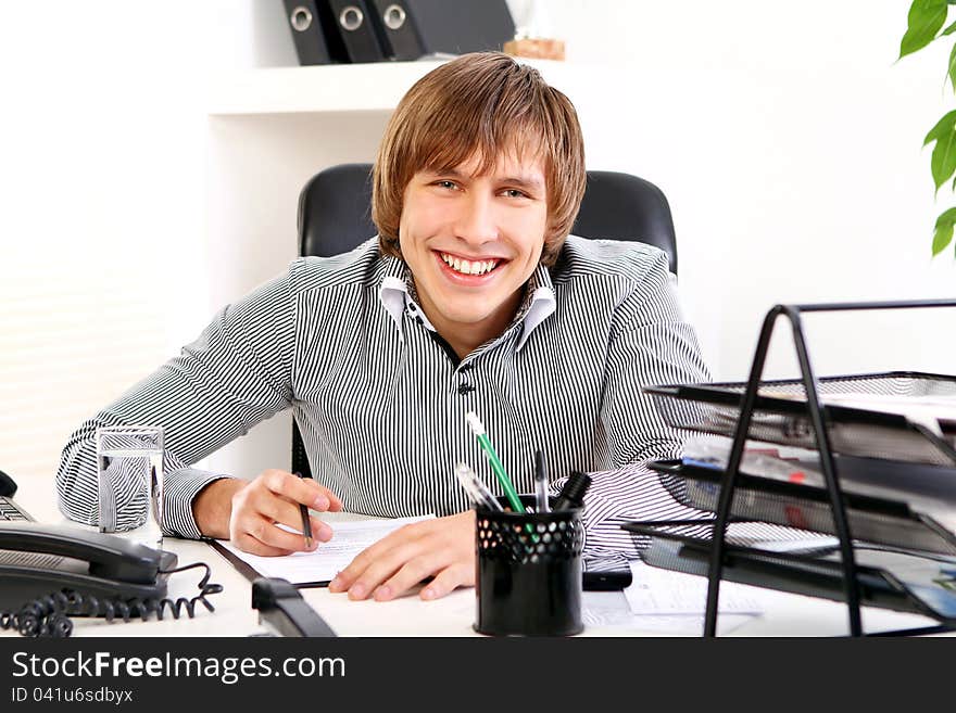 Young and successful businessman in his office. Young and successful businessman in his office