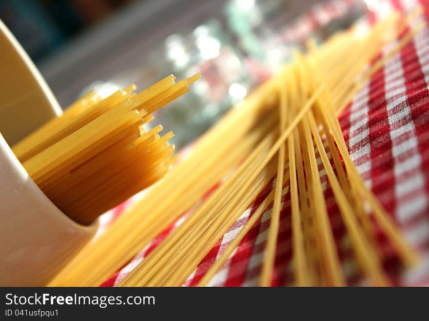 This photo shows a close-up of dried spaghetti spilled out on the table. This photo shows a close-up of dried spaghetti spilled out on the table