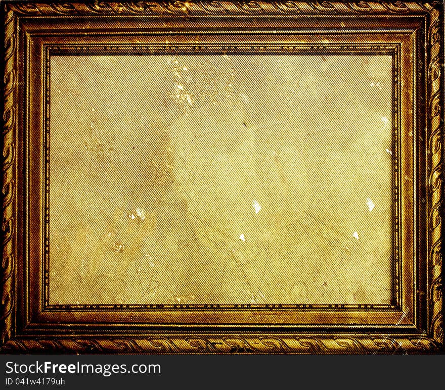 Old antique golden frame on grunge wall