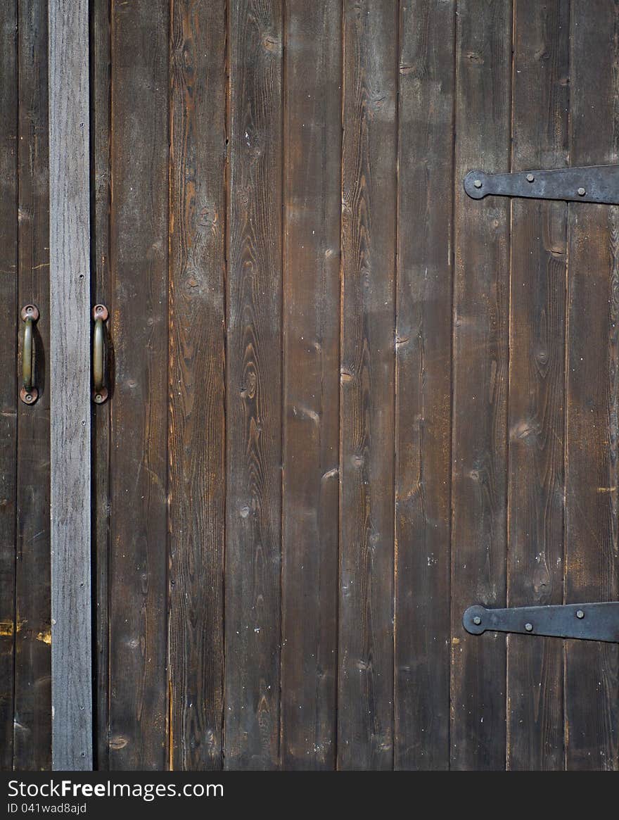 Large, old, wooden door, with metal handles and hinges