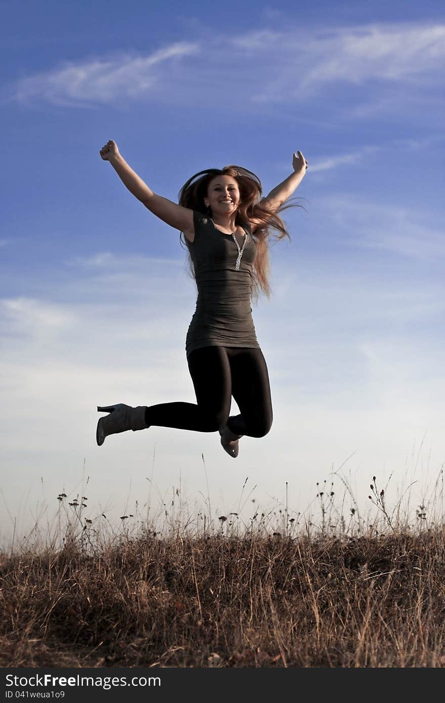 Beautiful girl jumps against the blue sky. Beautiful girl jumps against the blue sky