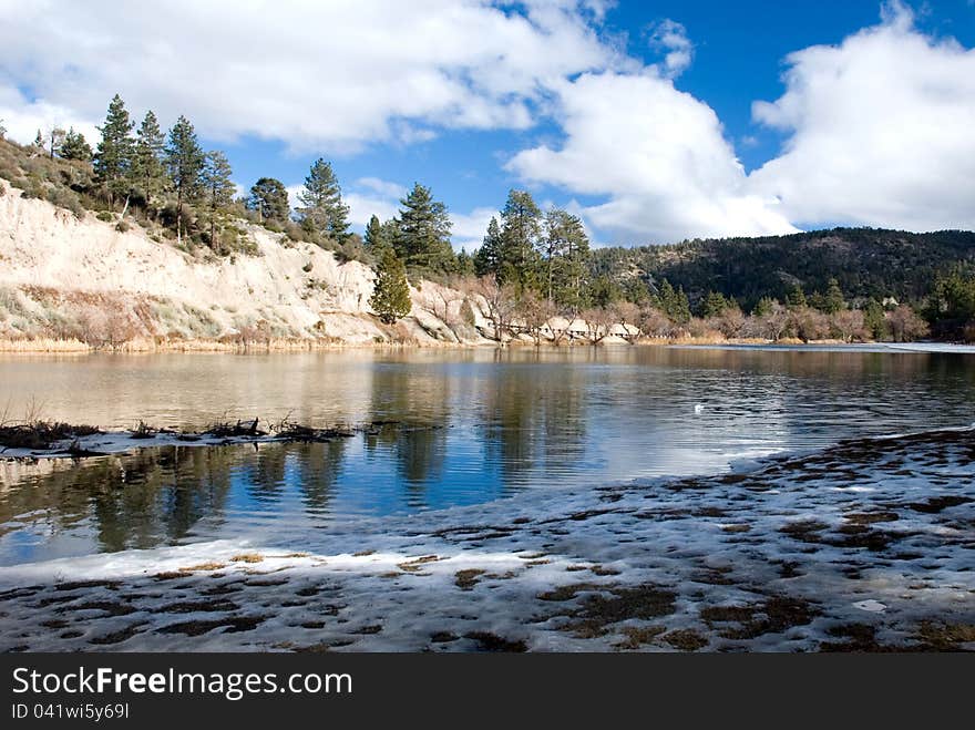 Beautiful winter day at the lake in the mountains. San Benardino National Forest. Sky and Trees reflecting off clear water. Beautiful winter day at the lake in the mountains. San Benardino National Forest. Sky and Trees reflecting off clear water.