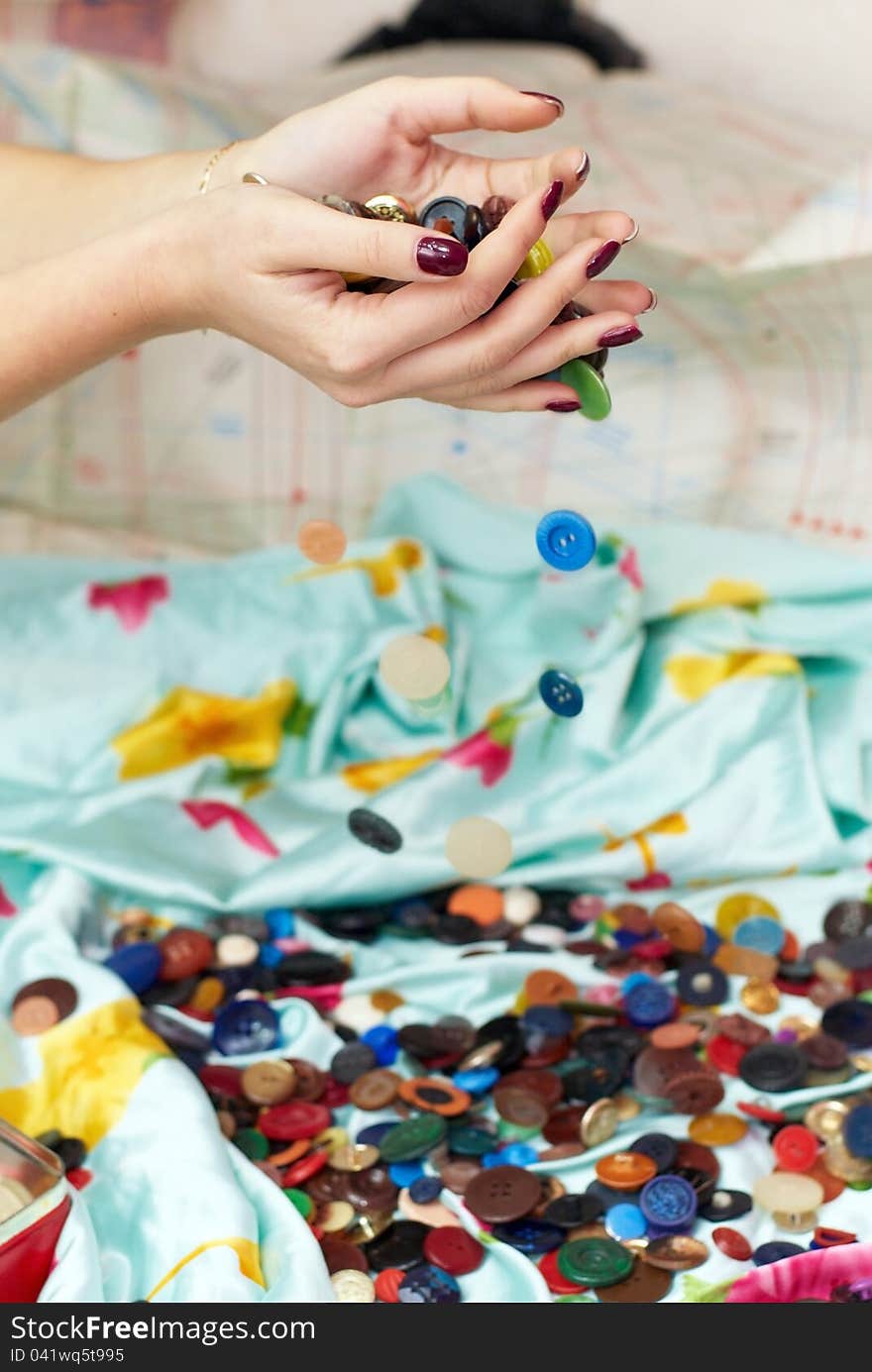 Female hands spilling buttons