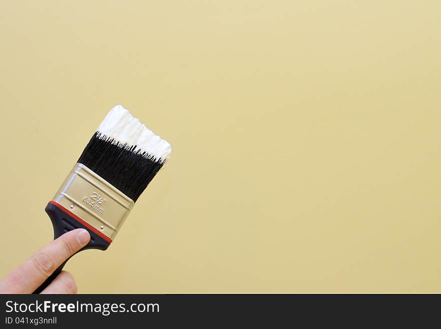 Hand with brush going to paint a wall. Hand with brush going to paint a wall.