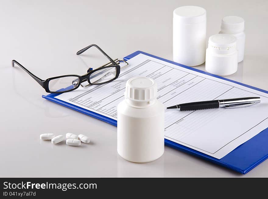 A report of a doctor and some medicals on a desk. A report of a doctor and some medicals on a desk