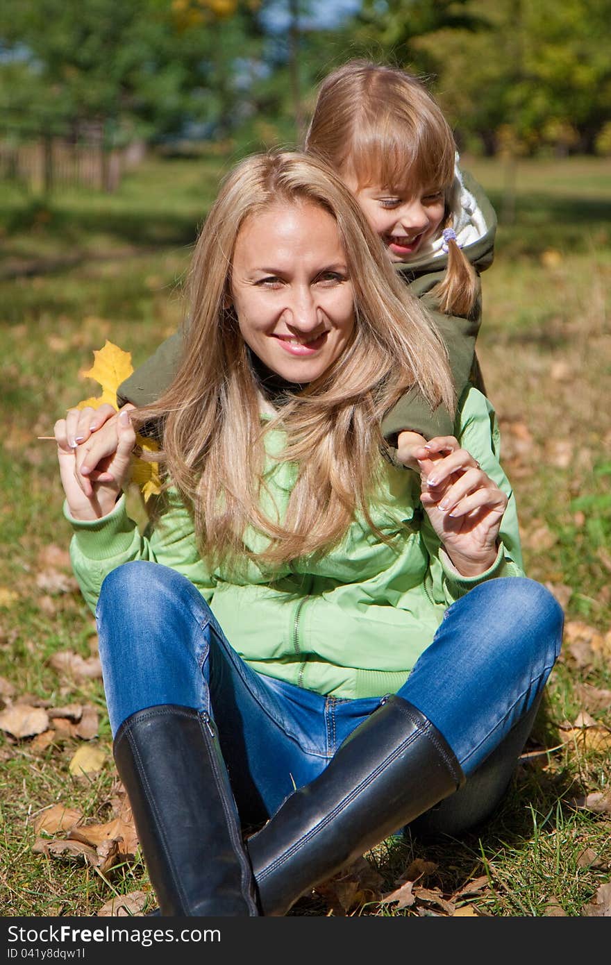 Young mother and her toddler girl in autumn fields