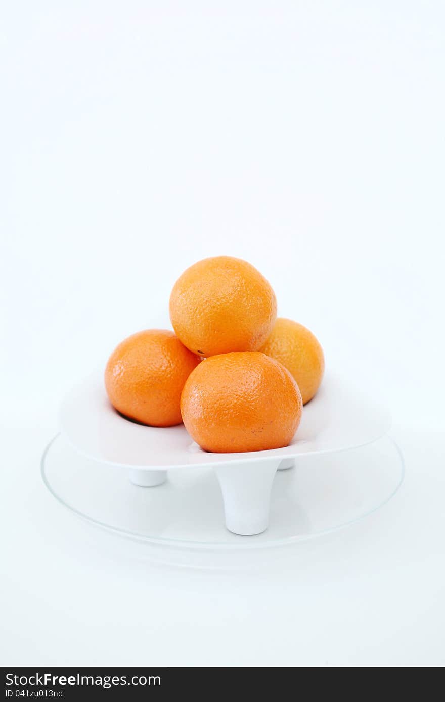 Three oranges in a white pot