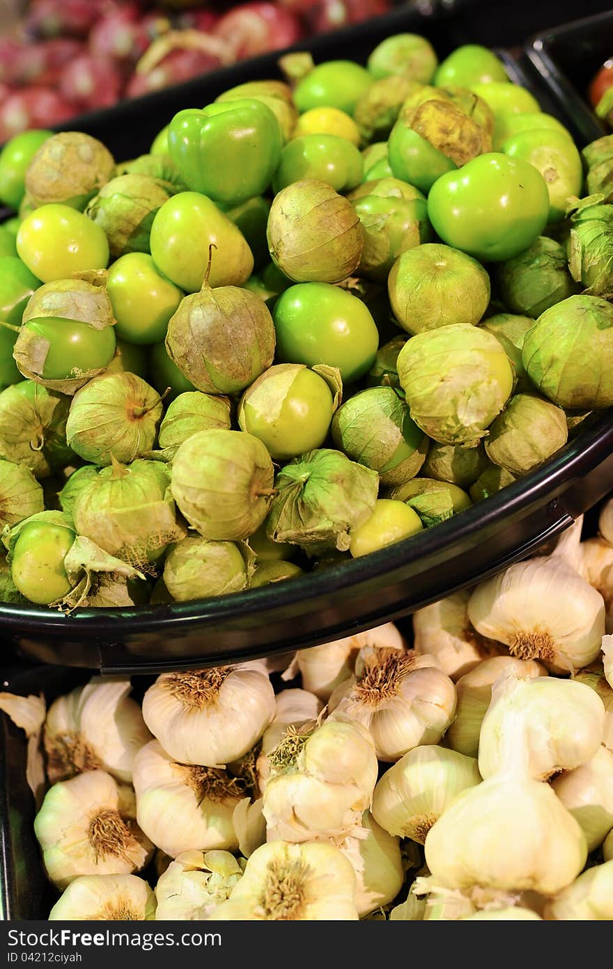 Fresh green tomatillos and garlic for sale at the market.