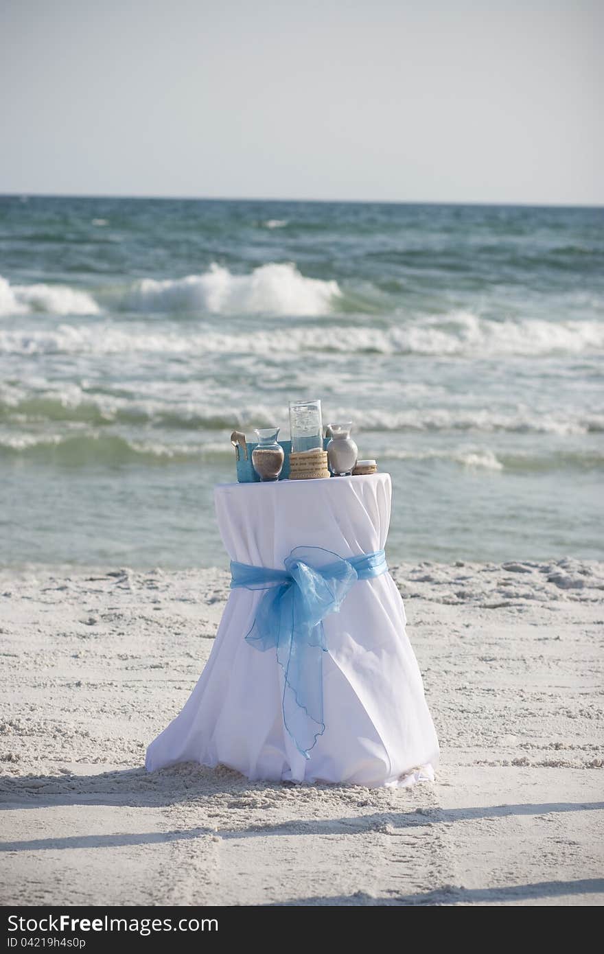 Horizontal photograph of a table used during a wedding ceremony on the beach. Horizontal photograph of a table used during a wedding ceremony on the beach