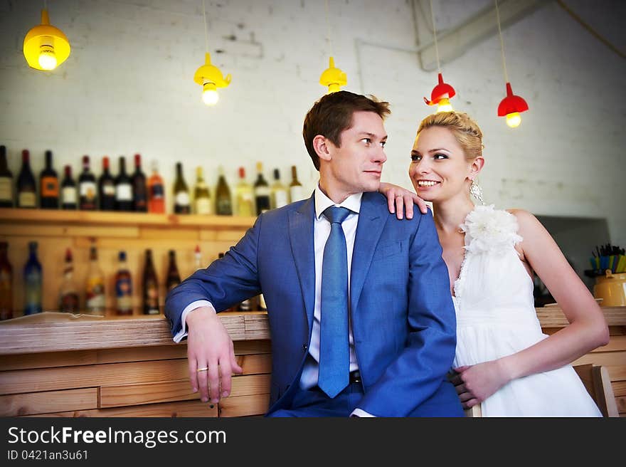 Bride and groom around the bar in the cafe