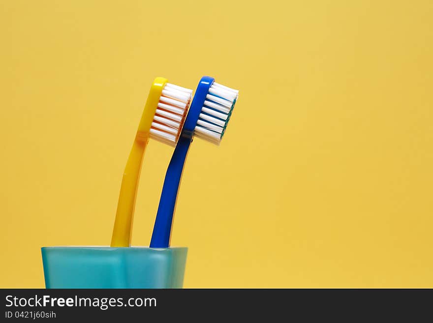 Toothbrushes On Yellow