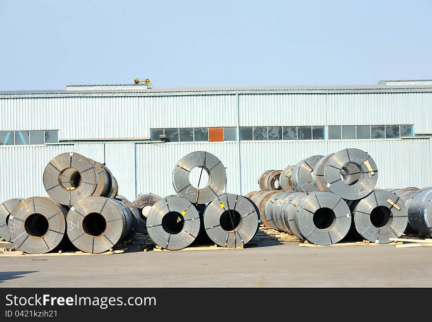 Rolls of steel sheet in harbor wait for loading