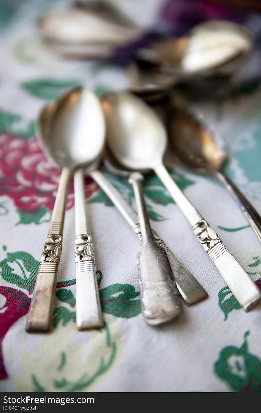 Vintage silver spoons on an antique tablecloth