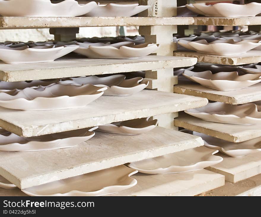 Ceramic plates in racks in ceramic work shop