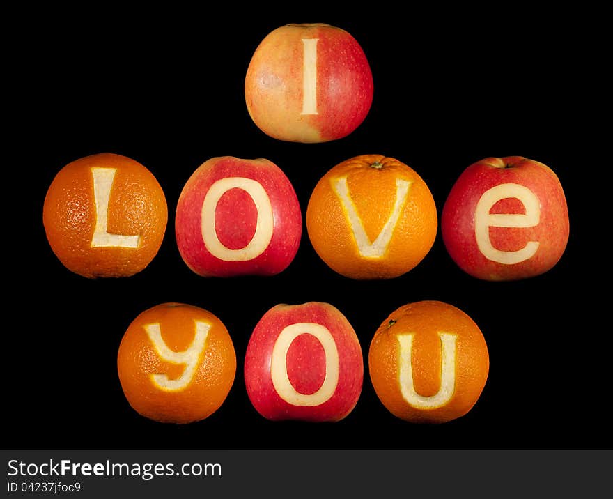 Declaration of love carved on apples and oranges isolated on black. Declaration of love carved on apples and oranges isolated on black