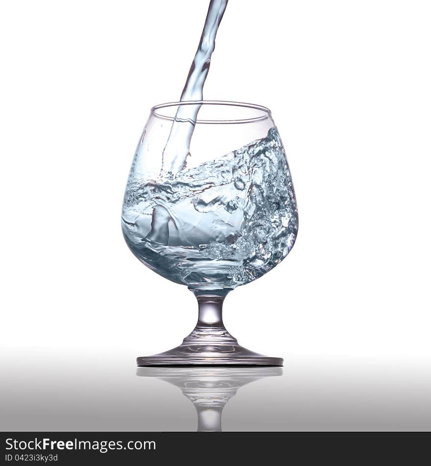 Water pouring into glass  on white background