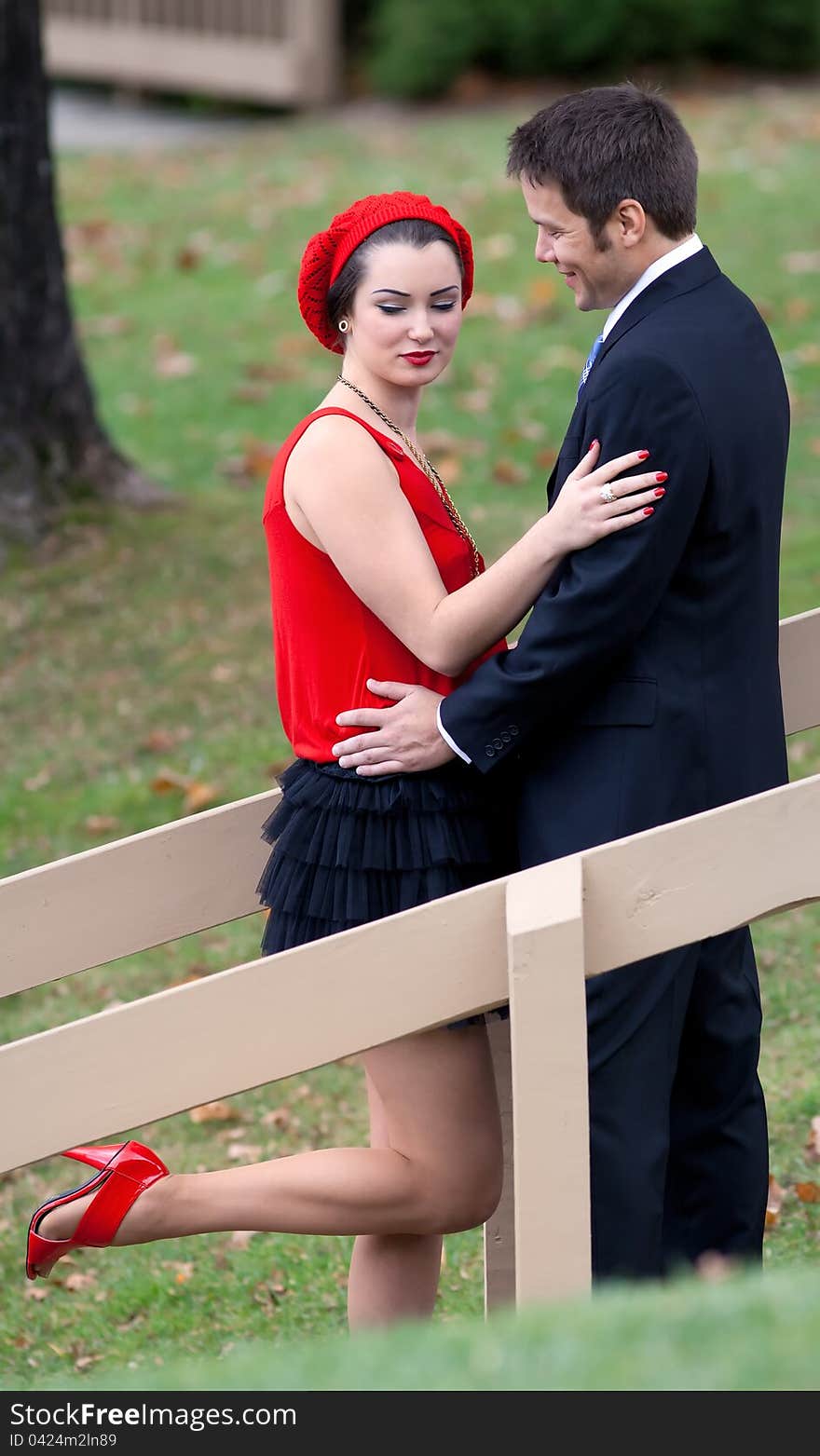 A portrait of a sweet, happy couple with their arms around each other in a lovely outdoor setting. A portrait of a sweet, happy couple with their arms around each other in a lovely outdoor setting