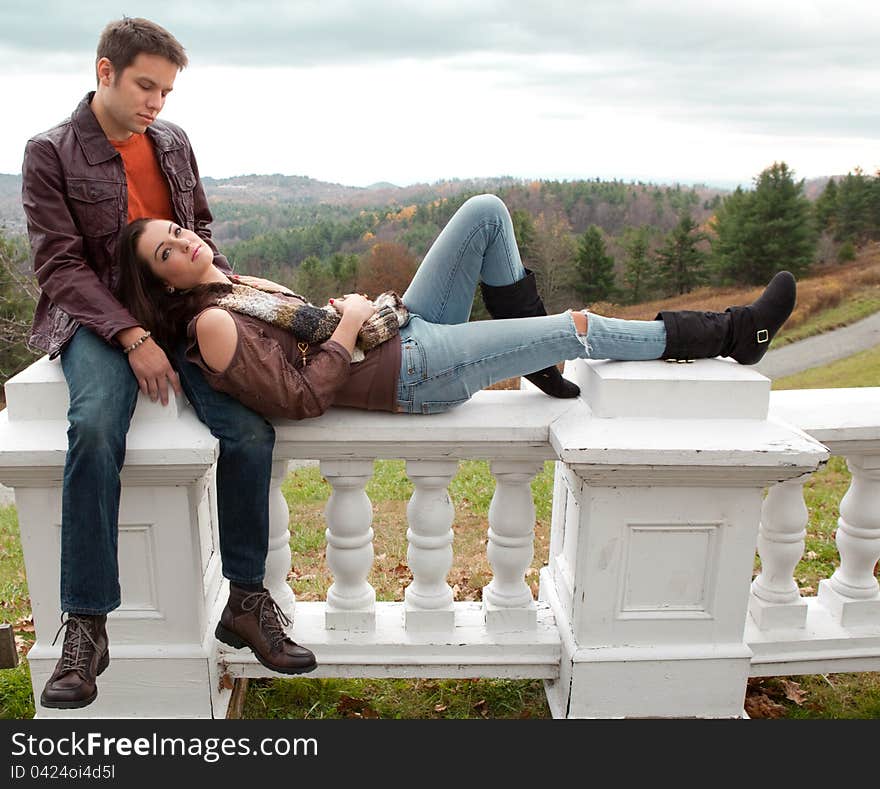 A portrait of a cute couple, relaxing together with mountains in behind them. A portrait of a cute couple, relaxing together with mountains in behind them