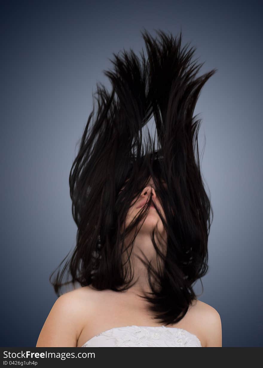 Beautiful girl with fluttering hair on dark background