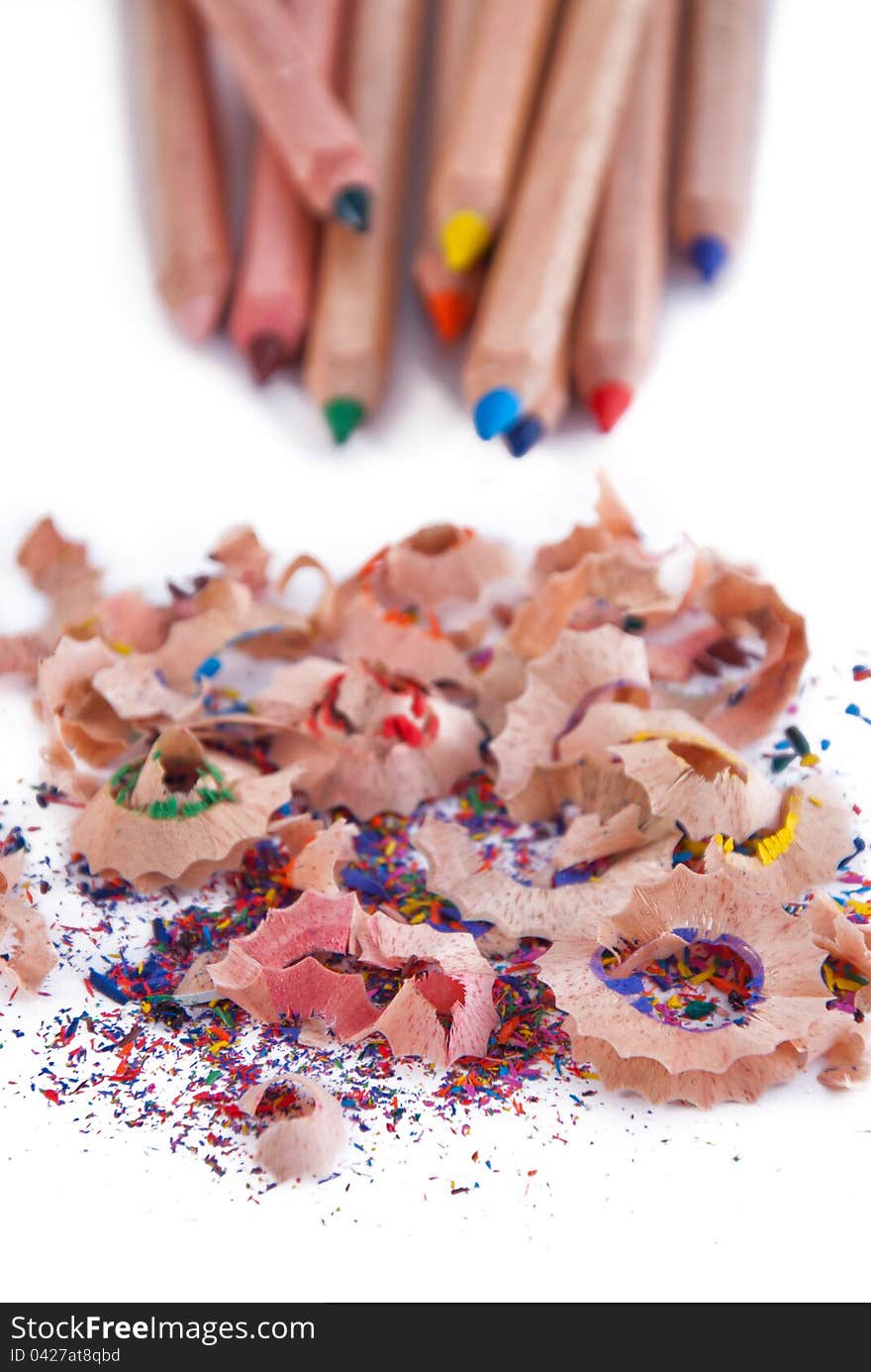 Multi-coloured pencil with crayon shavings, on white background. Multi-coloured pencil with crayon shavings, on white background