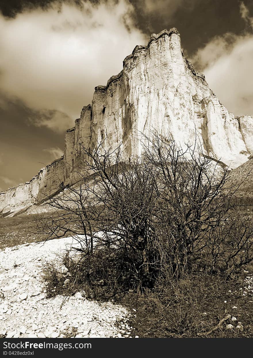 Rock \Belaja skala\ and a cloudy sky near Belogorsk, Crimea, Ukraine. Sepia image