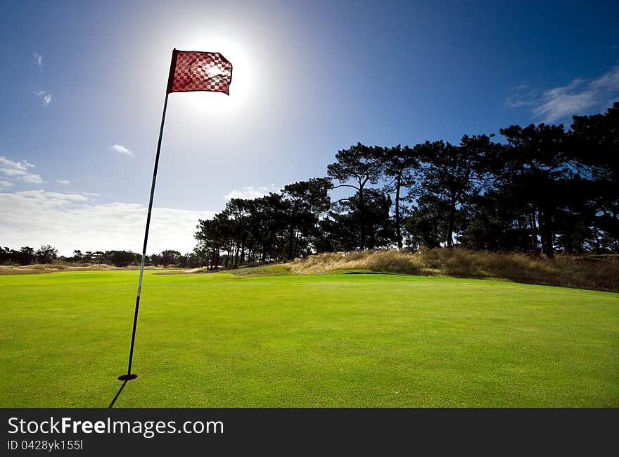 Sun shines behind a golf flag. Sun shines behind a golf flag