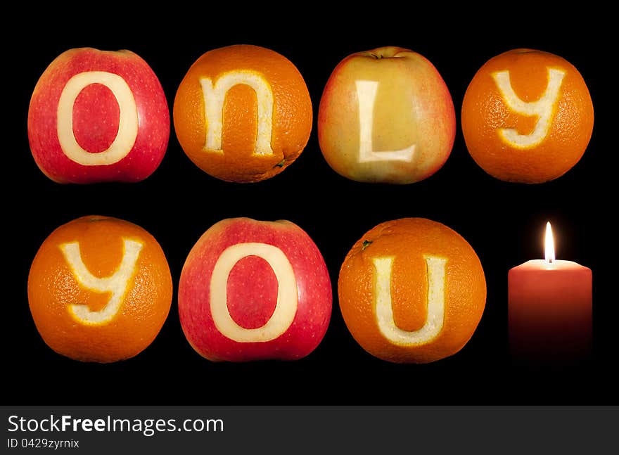 Words ONLY YOU carved on oranges and apples isolated on black. Words ONLY YOU carved on oranges and apples isolated on black