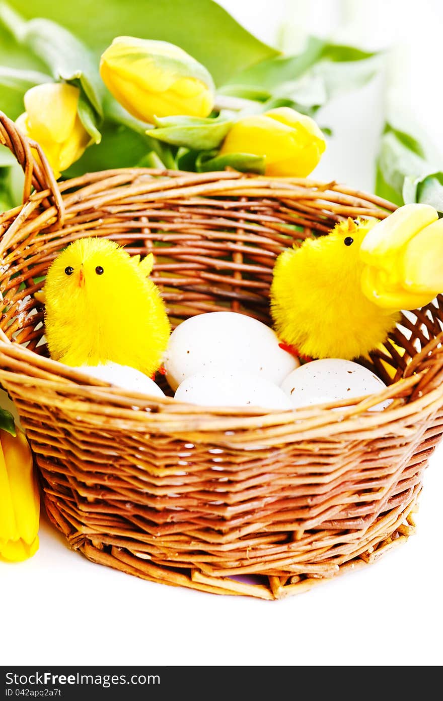 Two artificial chicks sit inside wicker basket. Two artificial chicks sit inside wicker basket