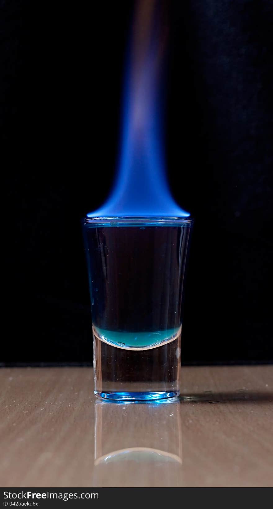 Burning drink in shot glass on a table