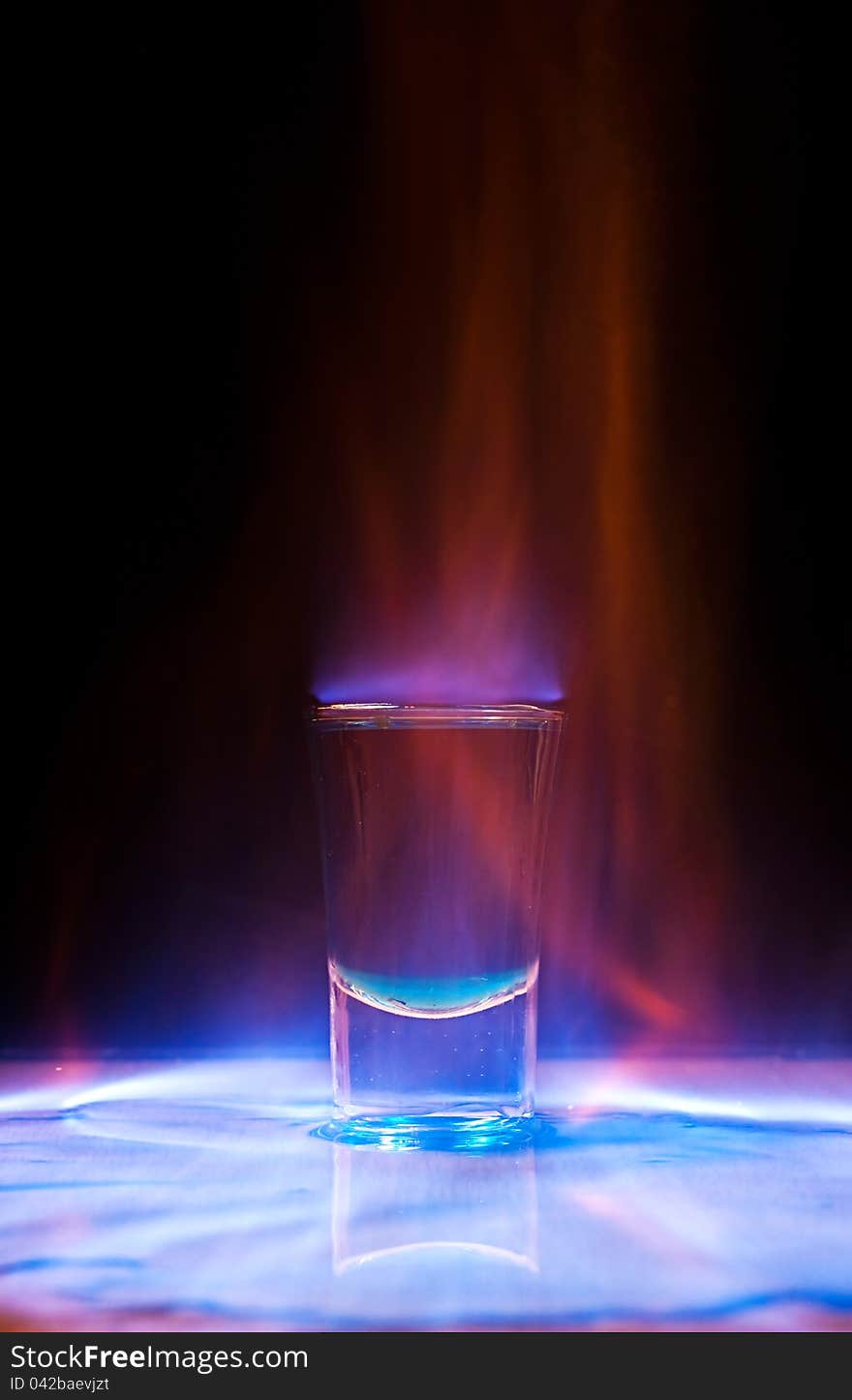 Burning drink in shot glass on a table