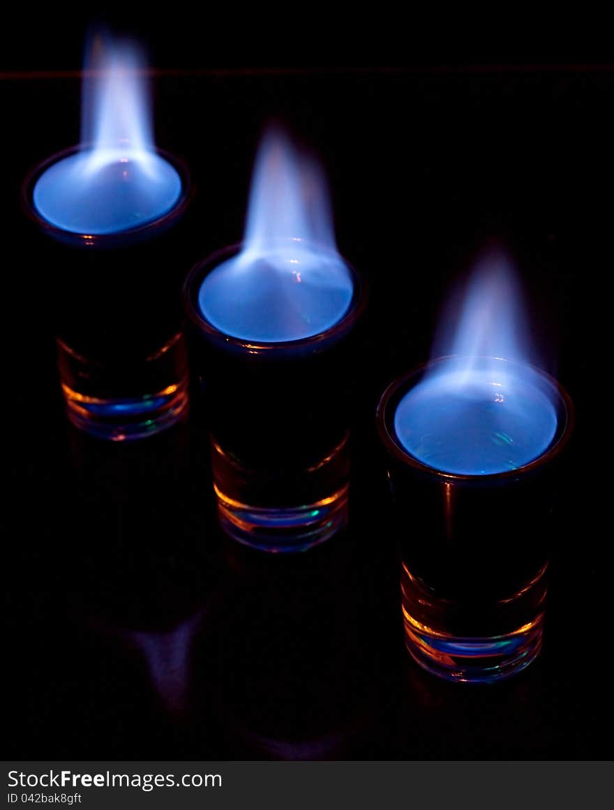 Burning drink in shot glass on a table