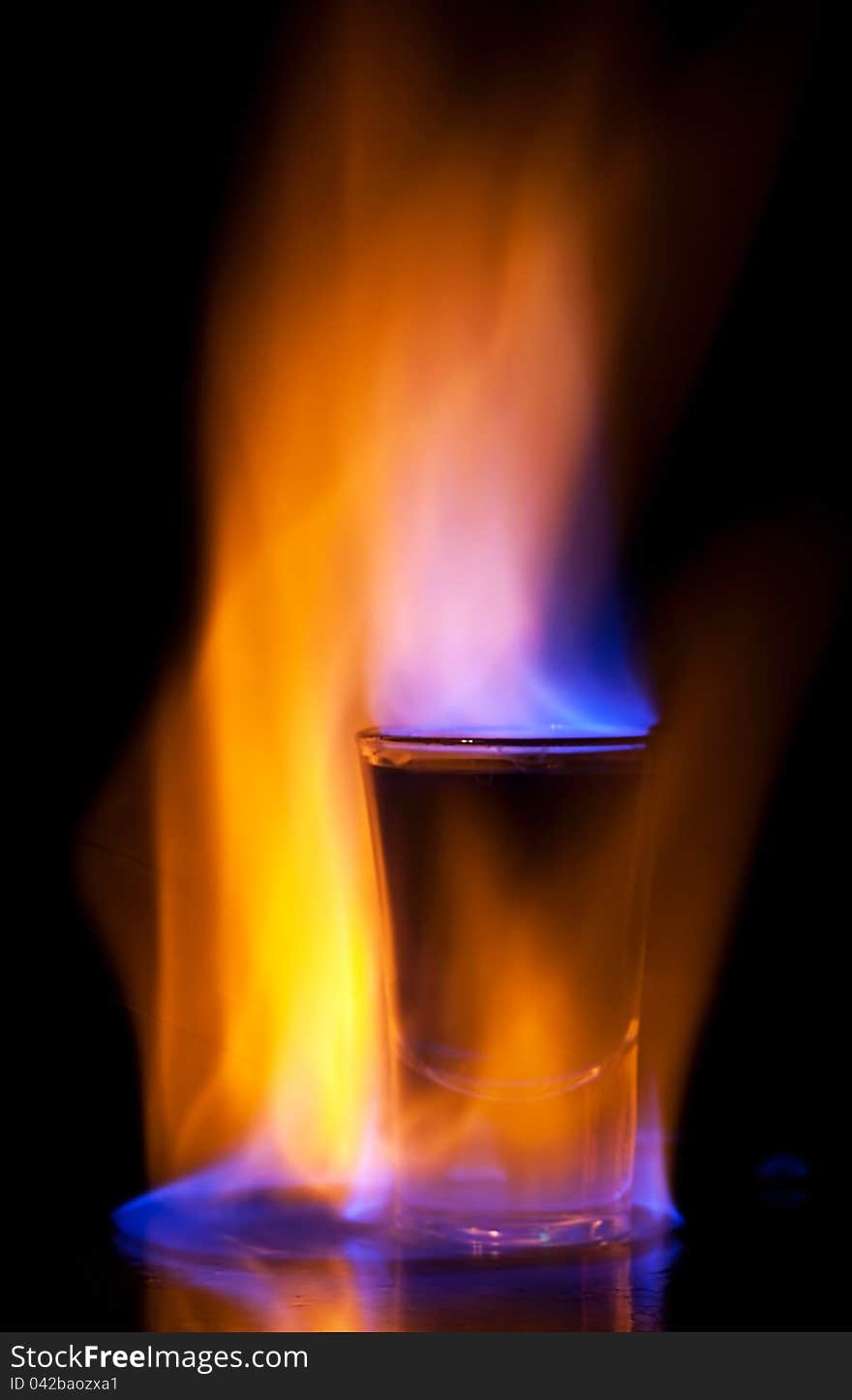 Burning drink in shot glass on a table