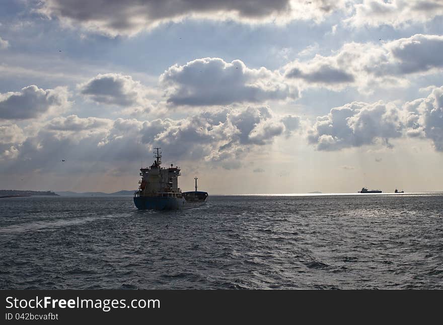 Cargo ship sails away in a cloudy day