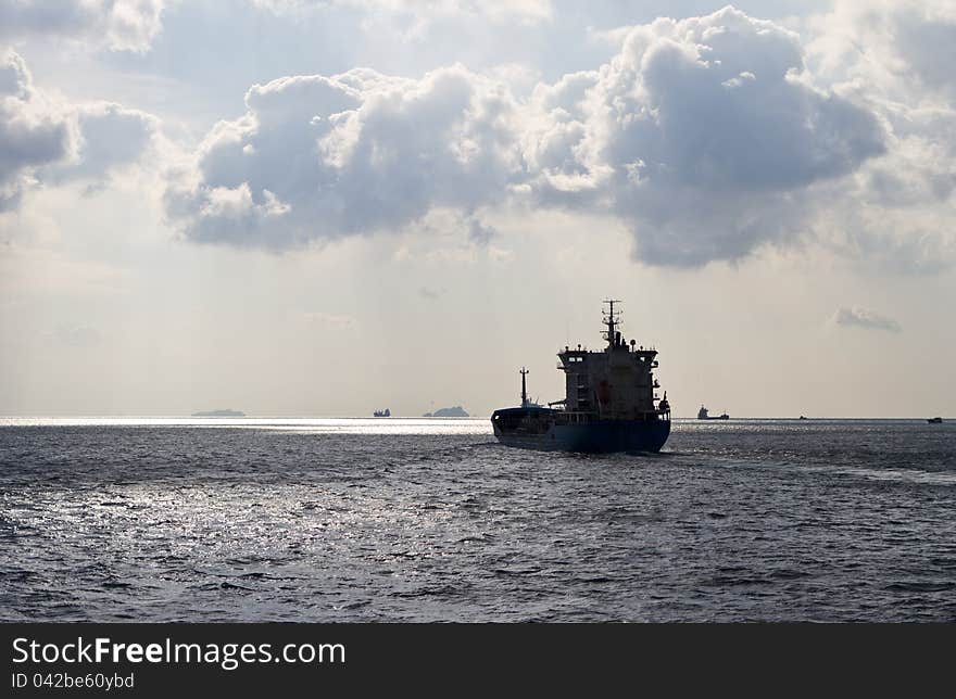 Cargo ship sails away in a cloudy day