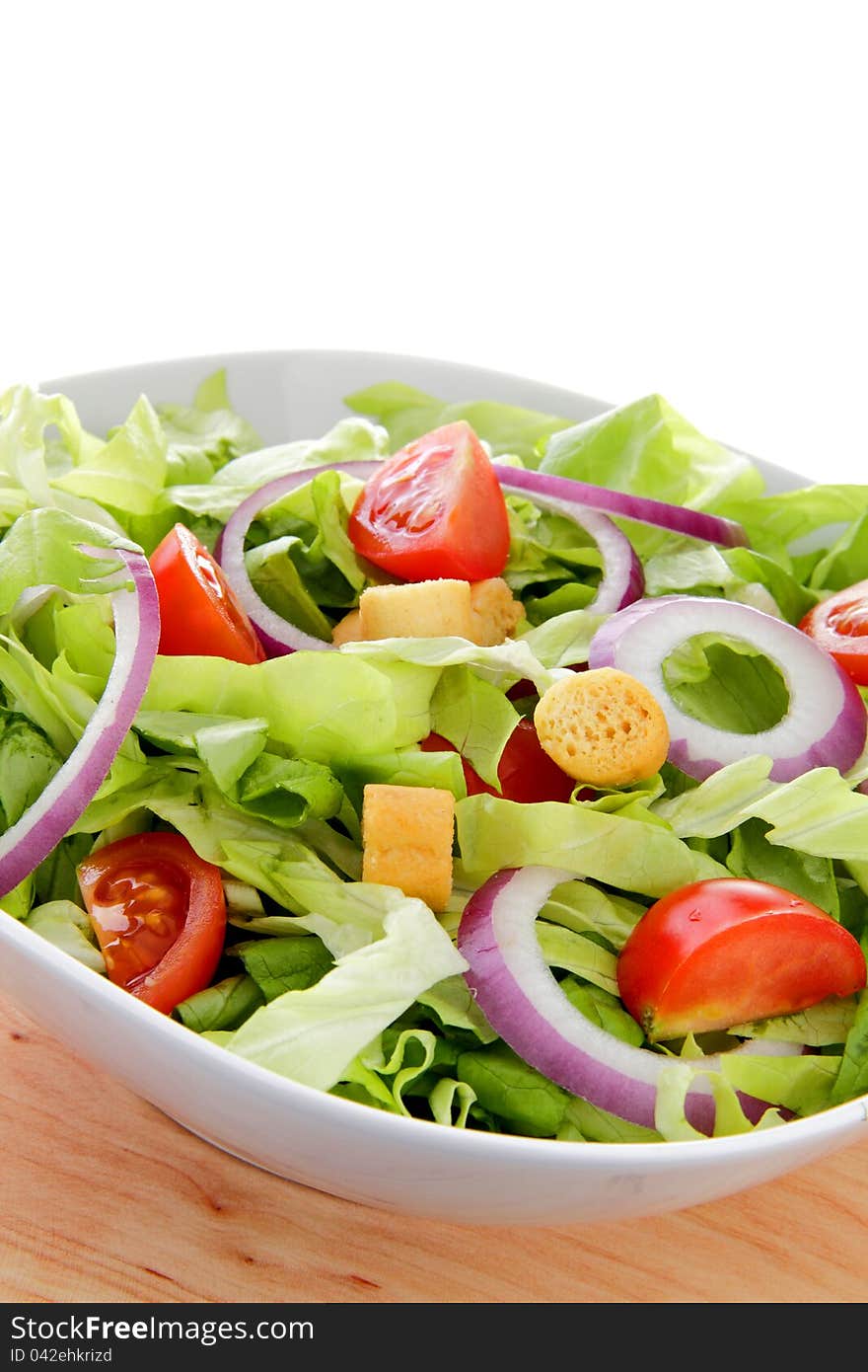 Delicious green salad whit tomato end union on the white background. Delicious green salad whit tomato end union on the white background