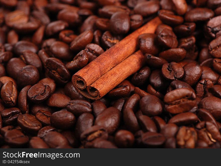 Macro photo of cinnamon sticks over coffee beans background. Macro photo of cinnamon sticks over coffee beans background