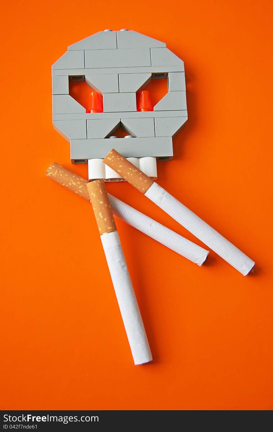 Skull and three cigarettes on orange. Skull and three cigarettes on orange