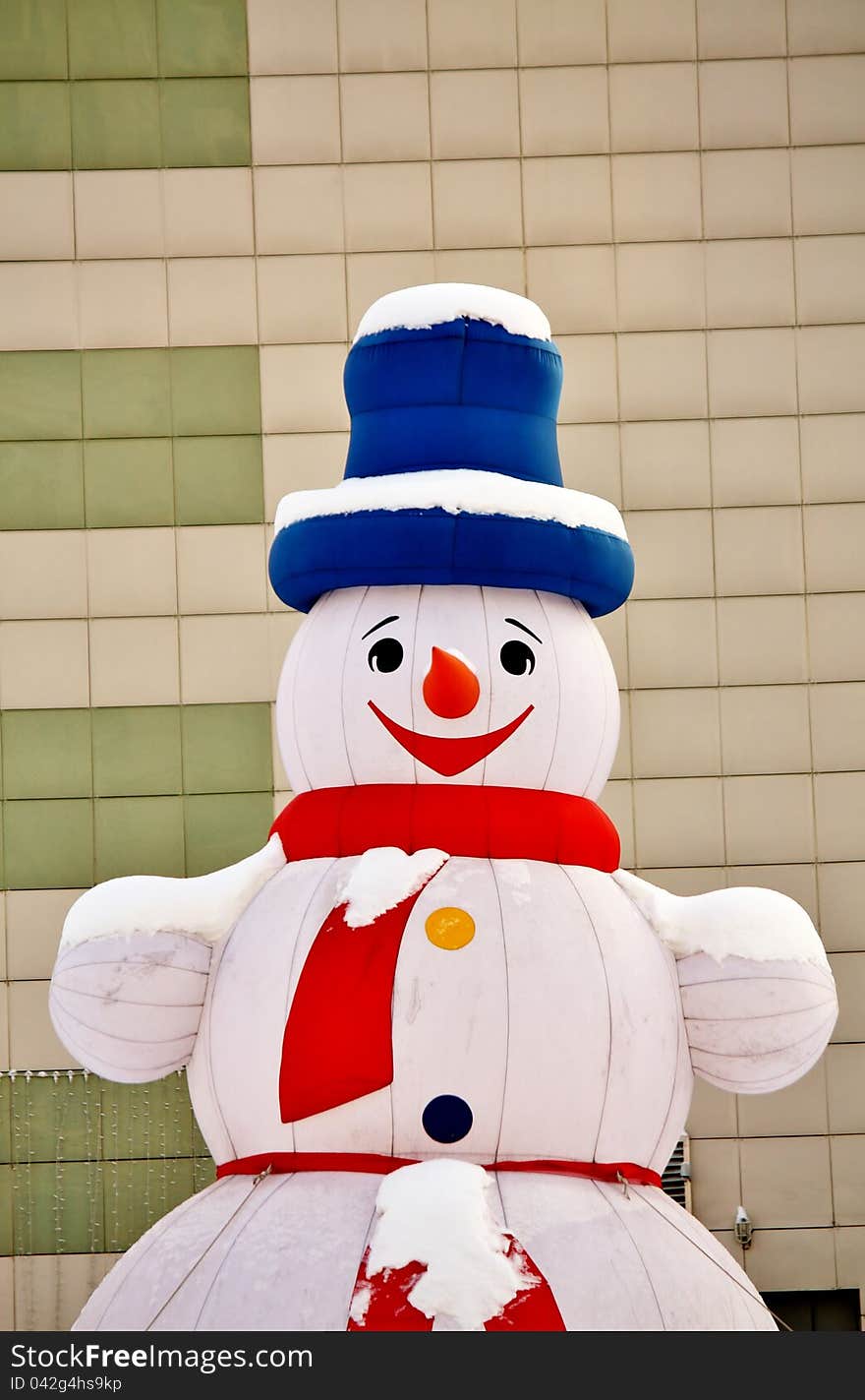 Snowman in a city court on the eve of New Year