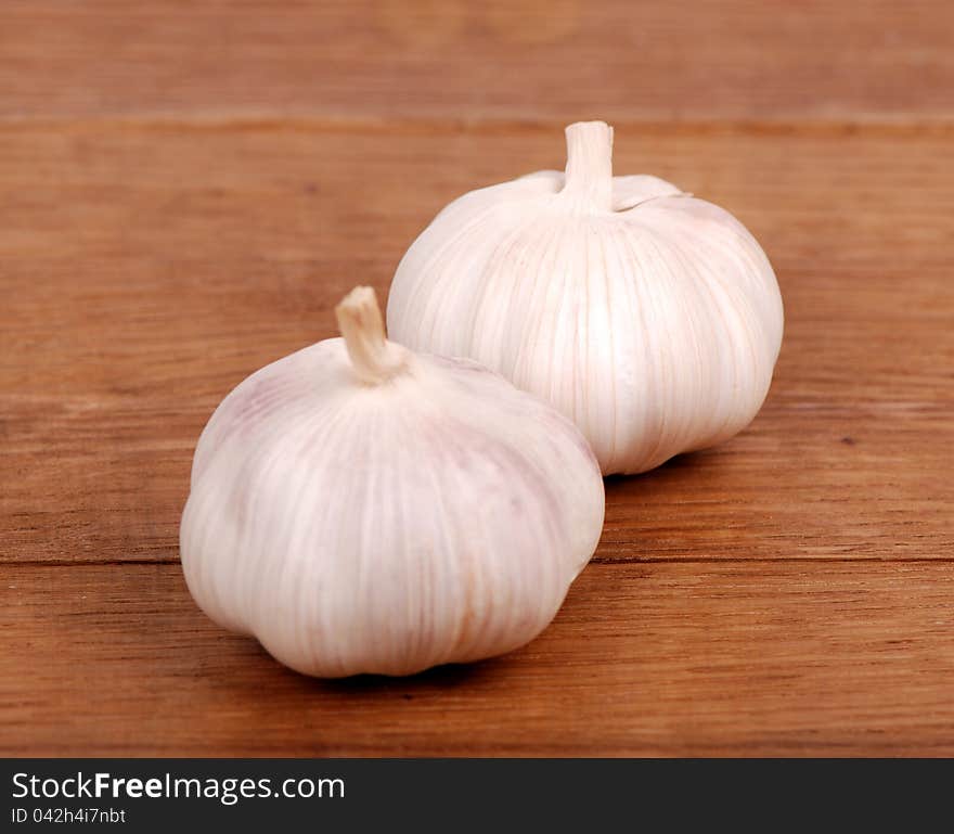 Image of two garlics over wooden background on food and drink theme concept