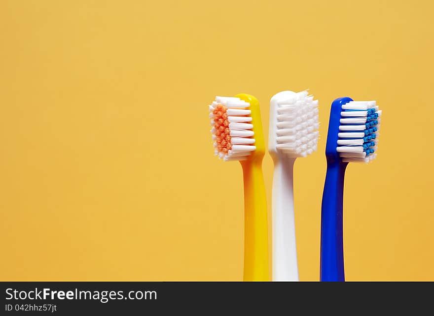 Toothbrushes On Yellow