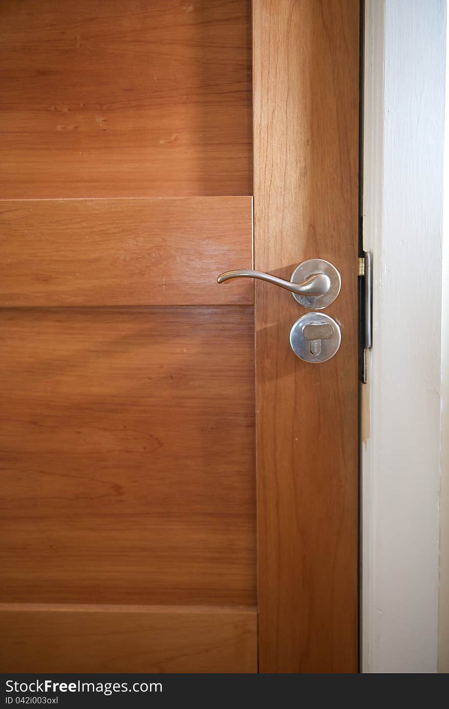 Wooden door close up with detail of steel handle and lock