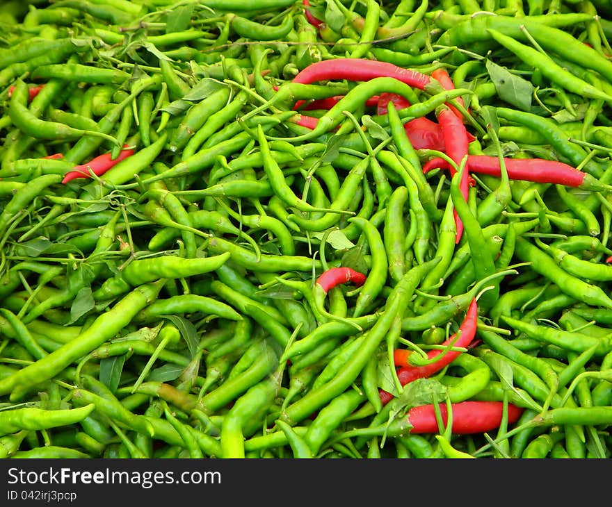 Pile of green and red hot chilli peppers