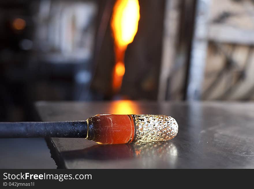 Glassblower shaping molten glass into a drinking goblet