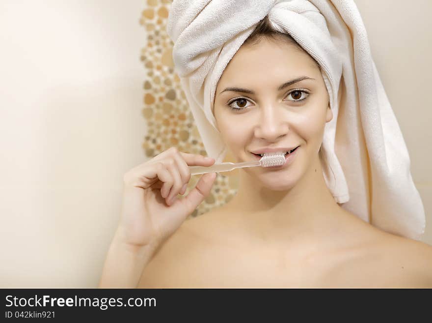 Young beautiful woman brushing her teeth